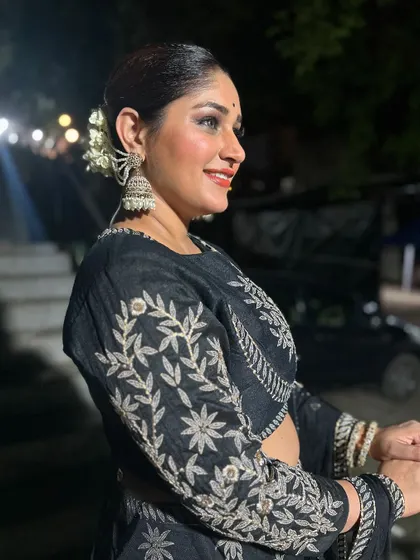 A close-up of Donam Bajwa's festive look, showcasing the intricate silver embroidery on her black lehenga blouse and her traditional jhumkas.
