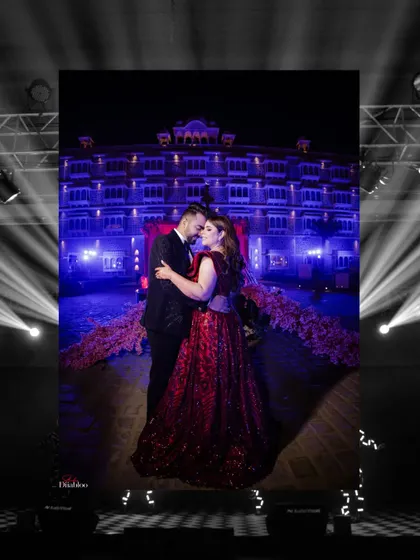 A stunning portrait of Jatin and Muskan against the backdrop of their palace venue, lit up with dramatic spotlights. This shot is the epitome of a grand, cinematic wedding photo.