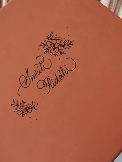 The gift box for the personalized mugs, itself personalized with the names 'Smriti' and 'Riddhi' and floral illustrations. The experience of a gift begins with the packaging.