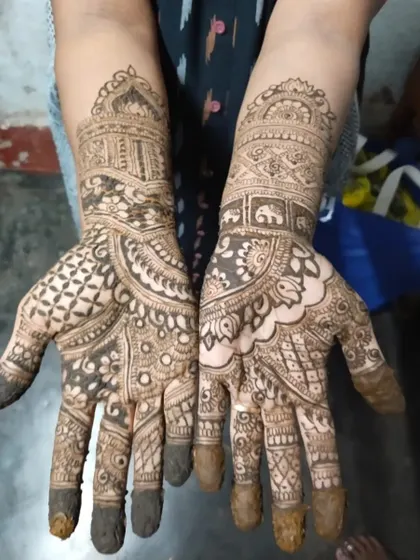 A complete traditional mehendi design on both hands, featuring architectural dome motifs and intricate filler patterns.