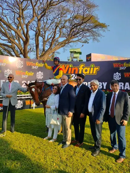The owners of Jamari, winner of The Winfair247 Bangalore Derby (Grade 1), pose proudly with their champion horse and jockey P. Trevor.