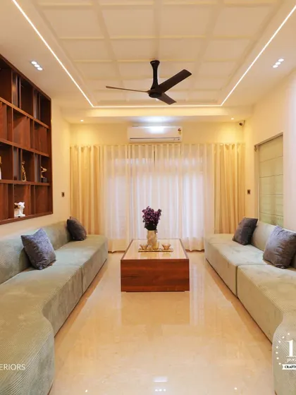 This formal living room is designed for spaciousness and comfort, with two large sofas creating a symmetrical and inviting layout. The coffered ceiling with concealed lighting adds a touch of architectural elegance.