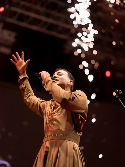 Singing for the crowd with pyro effects lighting up the stage. My live shows are a blend of serene sitar and high-energy moments, ensuring a dynamic and engaging experience for all.