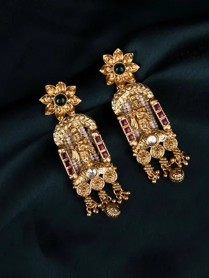 The same traditional earrings shot against a dark teal fabric, showing how the piece looks against different colors.