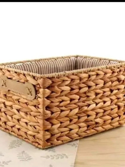 This sturdy, rectangular basket is woven from water hyacinth and includes leather-style handles for easy carrying. It's a stylish and functional piece for storing magazines, blankets, or other household items.