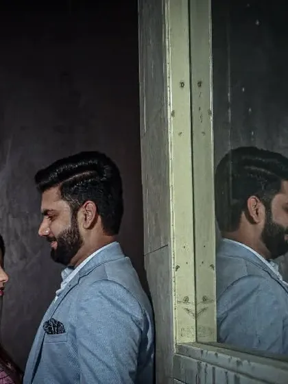 An artistic portrait using a mirror to capture the couple's reflection, adding depth and a creative angle to the shot.