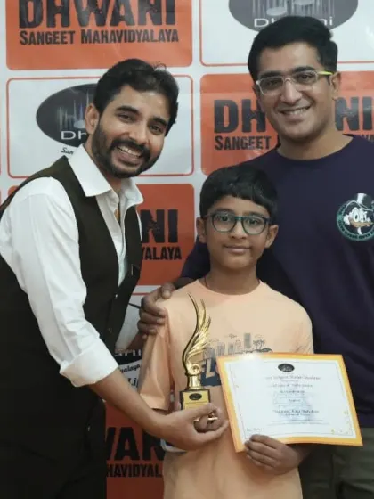 A student, his parent, and his teacher celebrating his win together.