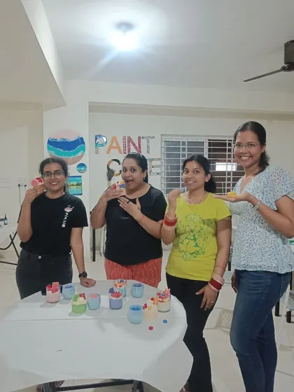 Participants joyfully showing their finished candles at our studio. The workshops are a great way to bond and create together.