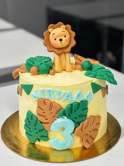 This cute jungle-themed cake was for Nirvaan's 3rd birthday. It features a sweet fondant lion on top, surrounded by monstera leaves and a festive bunting, all made from fondant.