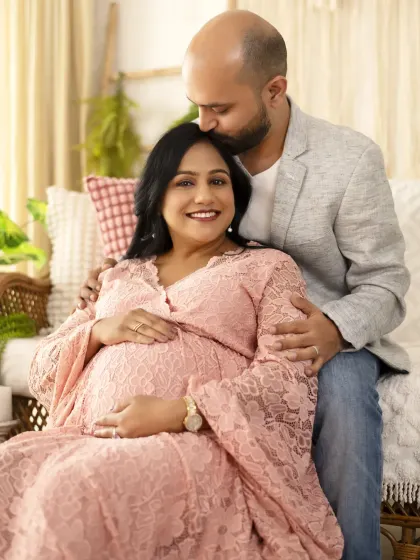 A happy, smiling portrait of a couple in our bright and airy studio setup. The dad-to-be’s gentle kiss on her forehead makes this a truly special memory.