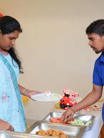 A staff member assists a guest at a birthday party buffet, showcasing our helpful service for smaller, intimate events.