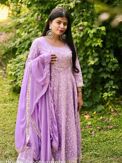An outdoor shot for an Amazon Fashion campaign, featuring a model in a lovely lavender suit set against a lush green background.