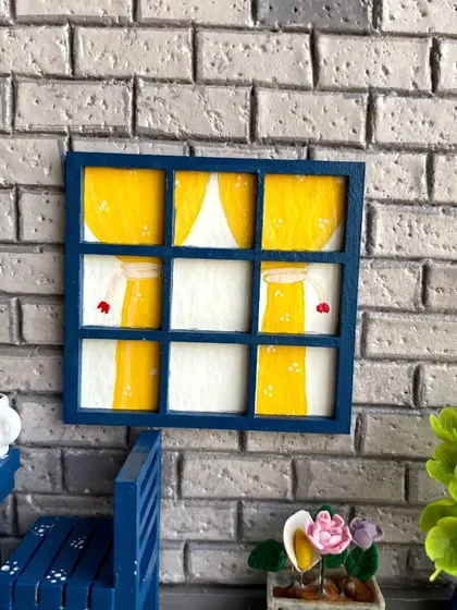 A close-up of the window detail. I hand-paint the curtains and add other small touches to make each element feel special and unique.