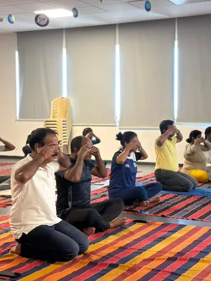 Employees participating in a facial yoga exercise to release tension in the jaw and face, which is common from stress and screen time.