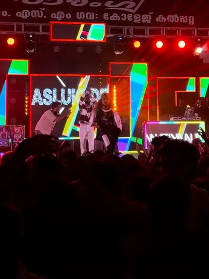 The full crew on stage at the end of a massive show, with the crowd still buzzing.