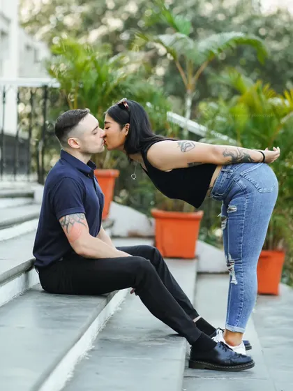 A sweet and playful kiss. This photo, taken on the steps of a building, is full of charm and affection.