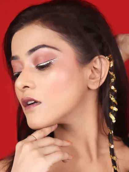 A close-up of a creative eye makeup look featuring a sharp, white glitter liner over a soft brown eyeshadow. This is a modern and chic style.