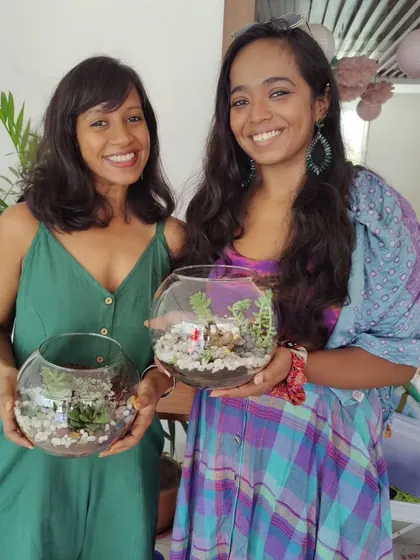 Two participants showing off their beautiful, finished terrariums. It's so rewarding to see the pride and happiness on their faces after they've completed their project.