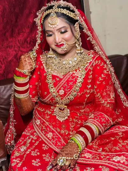 A happy bride adjusting her jewelry. This candid moment shows how the makeup looks natural and beautiful as she moves.