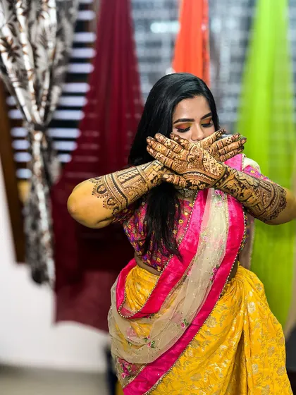 The lovely bride Bindu, posing with her beautifully done bridal mehendi, a perfect look for her special day.
