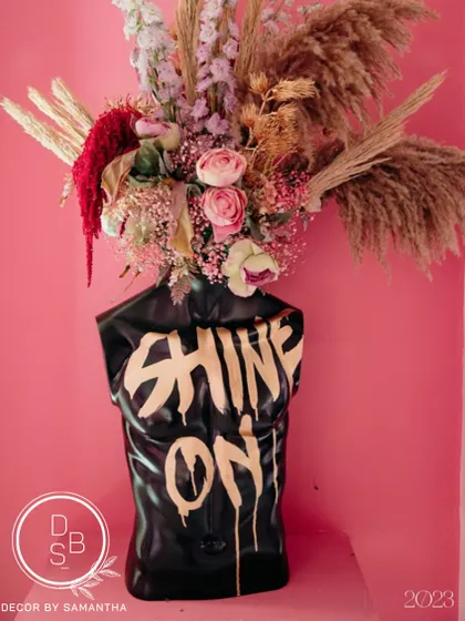 A true statement piece. This floral arrangement exploding from a bust with "Shine On" painted on it symbolized the burst of creativity in the wedding industry.