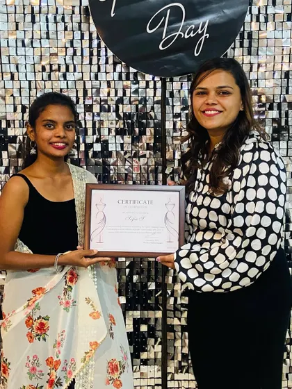 A student receiving her certificate of completion on graduation day. We are proud to see our graduates step into the fashion world.