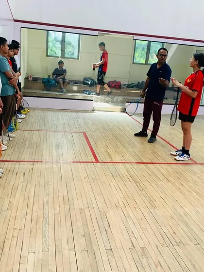 A group of students listens intently during a pre-drill briefing. Clear communication and ensuring every player understands the objective of the exercise are key to our coaching sessions.