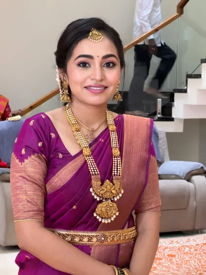 A smiling portrait of a client ready for a family function. Her makeup is polished and elegant, featuring a classic updo and makeup that enhances her beautiful smile.