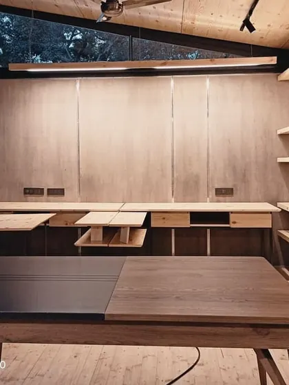 The interior of our Gazebo 1.0 project, a knock-down modular steel structure. The warm wooden interiors, including the ceiling, walls, and custom desks, create a comfortable and productive workspace within an energy-efficient, prefabricated frame.