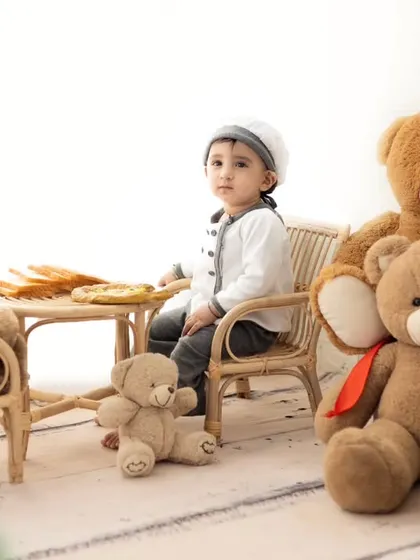 A teddy bear tea party with the little chef. This adorable setup is perfect for capturing the imaginative play of a toddler.