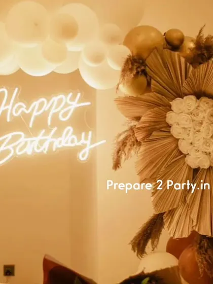 These close-ups of the 60th birthday decor highlight the detailed floral work made of dried palms and artificial roses, and the warm glow of the neon and marquee lights.