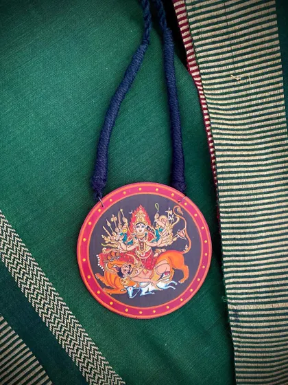 Another angle of the Durga pendant, showing the fine details of the painting.