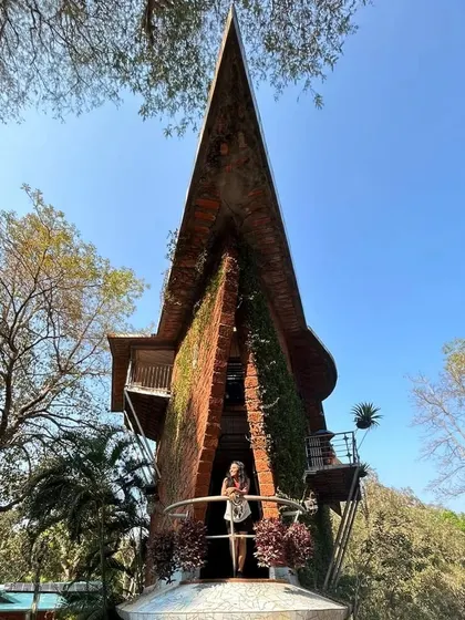 Posing at the unique, boat-shaped Houses of Goa museum. This shot combines architecture and travel with a confident modeling pose.