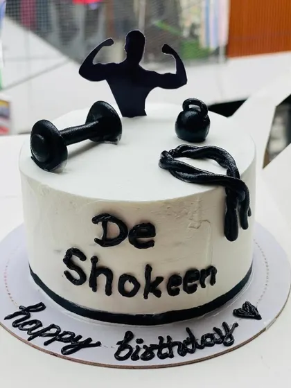 A fitness-themed cake for a gym lover, featuring dumbbells and a silhouette.
