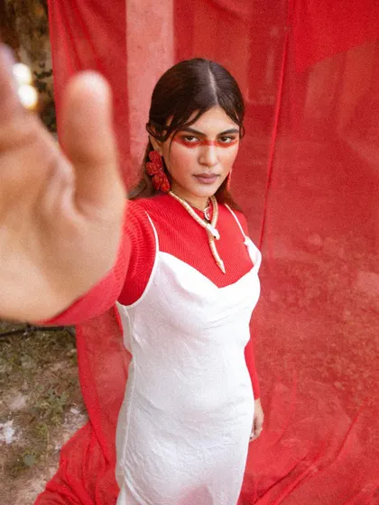 A creative shot from 'LUNA' where the model reaches for the lens, breaking the fourth wall.