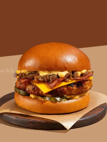 A bacon cheeseburger with caramelized onions, captured with clean lighting to make it look incredibly appetizing.