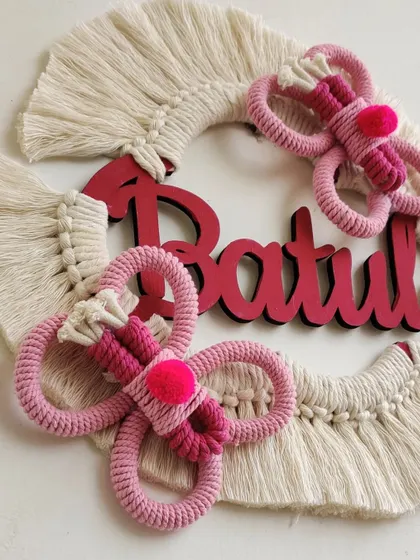 A close-up of the custom butterfly name hanging for Batul, showing the intricate pink knotting.