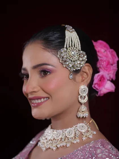 A side profile highlighting the elegant hair accessory and floral bun, which complete the Walima bridal look.