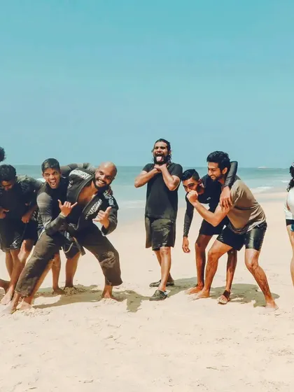This is the result of a hard day's work. A team forged by shared effort on the sands of the Udupi coast. We mix grappling drills with surfing, pushing our limits and then celebrating the progress together. Everyone, from beginners to advanced practitioners, is part of the crew.