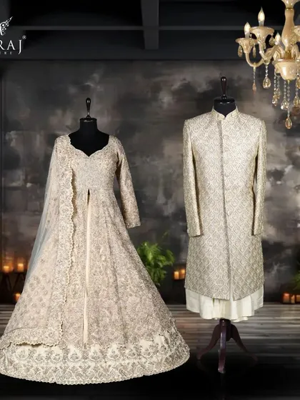 A vision of royal grandeur. The groom's light gold sherwani with multicolour embroidery stands beside a cream Indowestern masterpiece, both drawing inspiration from Persian art and adorned with intricate zardozi.