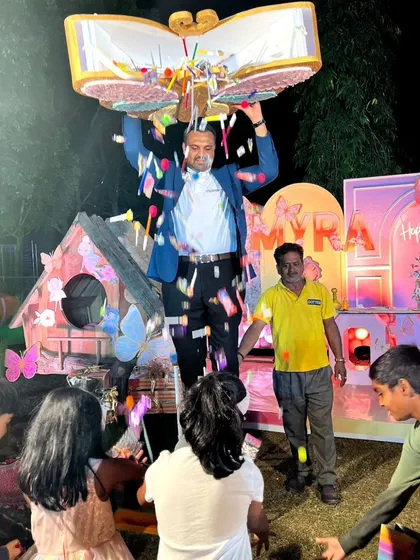 Another view of the piñata moment, this time with a giant butterfly-shaped book showering the kids with goodies. It's a moment of pure, chaotic joy.
