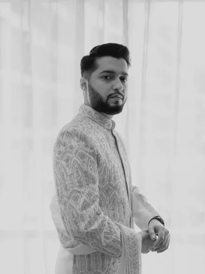 A classic black and white portrait of the groom, Sahil, looking sharp and ready for the ceremony.