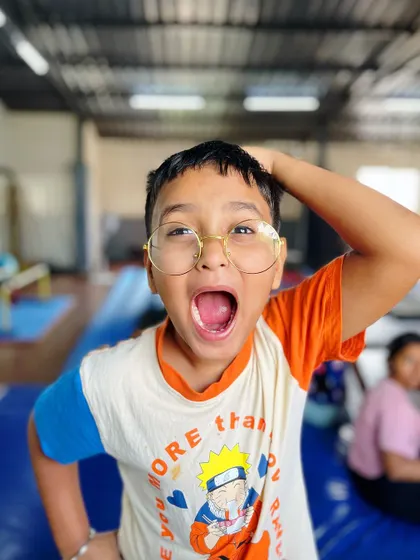The real magic wand is the child's own mind. This student's expressive face and playful pose capture the imaginative spirit we encourage.