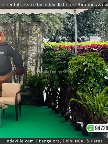 A photo booth area at an event, framed by rental plants provided by my team. The greenery helps to define the space and adds a natural touch to the corporate branding.