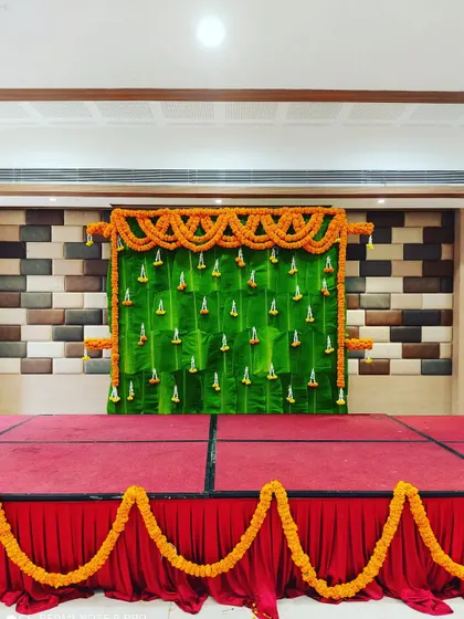 In addition to balloons, I also create traditional backdrops. This stage is decorated with a wall of banana leaves and marigold flower garlands, perfect for religious functions or traditional ceremonies.