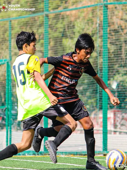 Speed and skill in action. A player dribbles past a defender during a Youth Championship match.