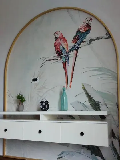 This arched wall feature is enhanced with a delicate wallpaper showing two parrots on a branch. It acts like a custom piece of art, adding a touch of elegance and nature to the room.