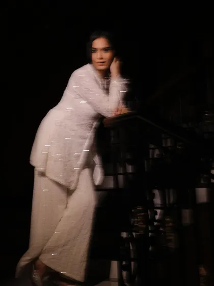 A creative motion-blur shot on a staircase, adding an artistic and dynamic feel to the white outfit.