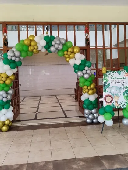 A jungle-themed entrance arch made with green, gold, silver, and white balloons, setting the stage for the party.