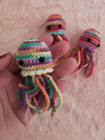 Another look at the tiny rainbow jellyfish charm held in my hand. The mix of colors makes each one a unique piece of art.